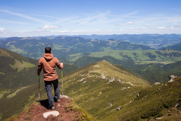Hombre de pie en la cima de la montaña — Foto de Stock