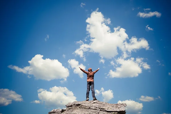 Man standing on the top of the mountain over blue sky — Stock Photo, Image