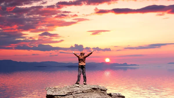 Mann steht auf dem Gipfel des Berges über Ozeanlandschaft — Stockfoto