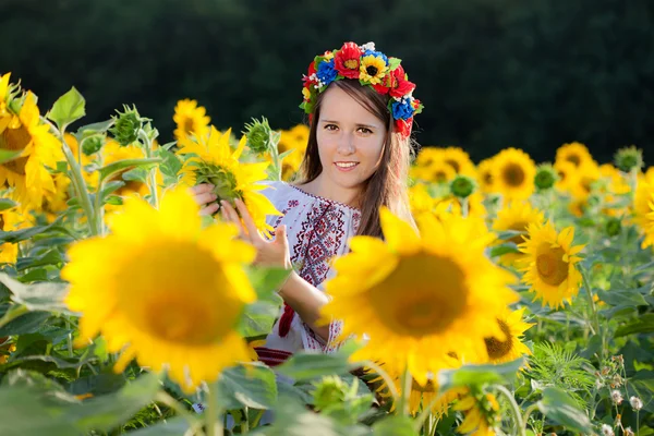 Schönes junges Mädchen im Sonnenblumenfeld — Stockfoto
