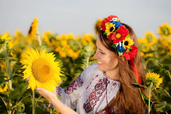 Krásná mladá dívka v slunečnicová pole — Stock fotografie