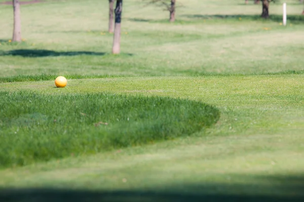 Bola de golfe no campo de golfe verde — Fotografia de Stock