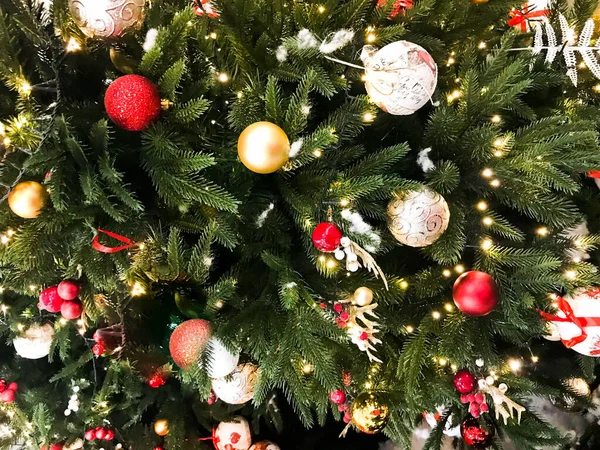 Abete rosso decorato con vari giocattoli. i rami sono decorati con palle rotonde lucenti di colore d'oro. decorazione della vigilia di Natale, casa e centro commerciale — Foto Stock