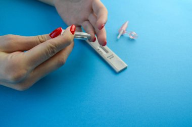 İgm ve IgG 'nin Corona virüsü SARS-CoV-2' yi geliştirerek Covid-19 hastalığına neden olan özel antikorların tespiti için hızlı COVID-19 testi. Mavi nane arkaplanında el ele tutuşma testi.