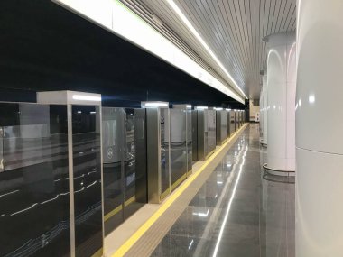 Güvenliği arttırılmış metro. Yeni metro istasyonları. Çifte güvenlik, trene girmeden önce otomatik kapılar. Metro istasyonundaki büyük beyaz sütunlar.