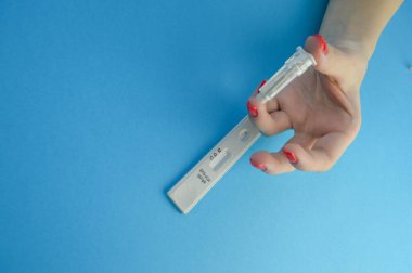 Koronavirüs teşhisi için kan testi. Mavi bir arka planda test bandı ve parmak deliği. IgG ve IgM antikorlarının belirlenmesi.