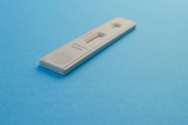 individual set for self-diagnosis of coronavirus. test strip on a blue matte background. window for a drop of blood, test for self-blood analysis.