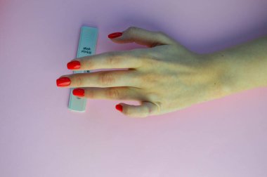 Pembe bir arka plan üzerinde koronavirüs testi. Tıbbi prosedür. Tıbbi analiz. Kız testi yapar, sağlık durumunu değerlendirir..