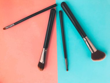 Düz yatıyordu. Pembe arka planda, üzerinde fotokopi alanı olan altın makyaj fırçaları..