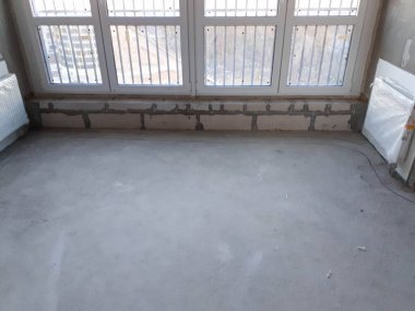 Monolitik çerçevesi olmayan, duvarları gaz silikat bloklarından yapılmış açık bir planı olan yeni bir apartmanın yeni stüdyo dairesine büyük bir panoramik pencere..