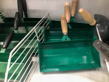 Tamir aleti. Bahçe için aletleri olan bir hırdavatçıda rafta. Toprağı ve yerdeki döküntüleri temizlemek için kazıyıcılar. Bahçe aletleri.