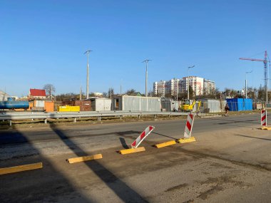 Köprü altında sanayi çalışmaları ve asfalt silindirler gibi modern inşaat ekipmanlarının da yardımıyla büyük otoyol üstgeçidi inşa ediliyor..