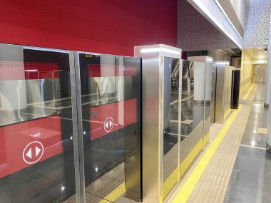 Yeni modern bir metro istasyonunda otomatik kapı peronu sistemi. Metro güvenlik sistemi. Güzel kapılar, gelen vagonun kapılarıyla senkronize olarak açılıyor..