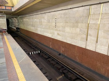 Metro istasyonunda bekleyen granit duvarlı trenler için platformdaki tünelin görüntüsü..