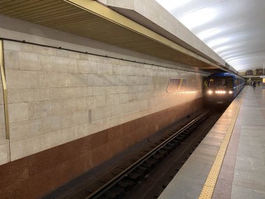 Metro istasyonunda bekleyen granit duvarlı trenler için platformdaki tünelin görüntüsü..