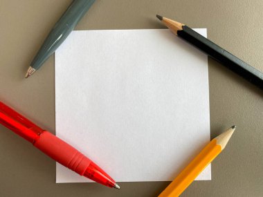 Ofis masasındaki notlar ve tükenmez kalemler için küçük kare kağıt parçaları. İş çalışması.