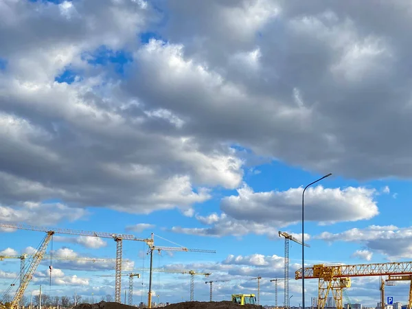 Construction site. Contemporary urban landscape. Big industrial tower crane with blue sky in background. Modern civil engineering. Beautiful photo of a construction crane against sky.