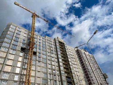 İnşaat endüstriyel yüksek kule vincinin yardımıyla inşa edilen büyük, bitmemiş yeni bir bina..