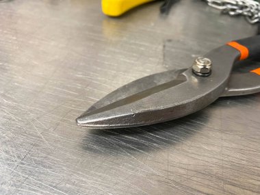 Demir gibi keskin metal makas, metal makaslar demir bir masanın üzerinde yatar. El yapımı çilingir aletleri. Arkaplan.