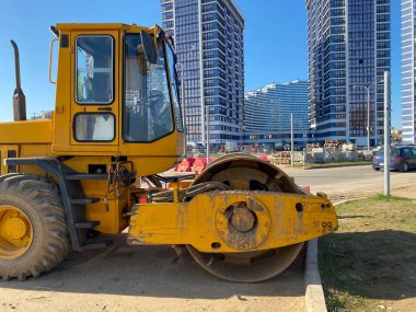 Asfalt yol tamiri sırasında inşaat alanında çalışan bir yol silindiri. Asfalt döşeme üzerinde paten makinası.