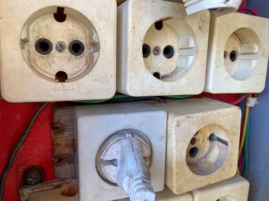 Büyük beyaz profesyonel olmayan elektrik paneline bir sürü kare elektrik prizi yerleştirdi.