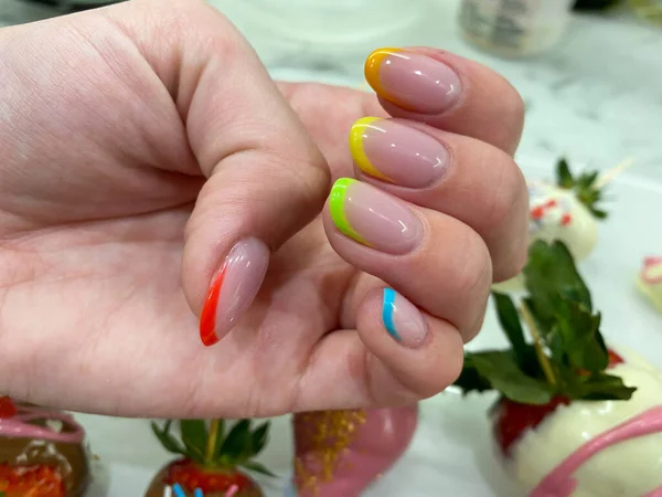 Rainbow design on long oval nails. Nail art. Multicolored French manicure.