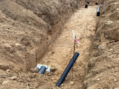 Şehrin kanalizasyon sisteminin yeniden inşası için inşaat sahasında sıra sıra dizilmiş plastik PVC borular.