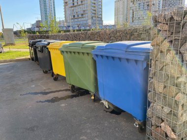 Siyah, sarı, yeşil ve mavi plastik büyük modern kaplar ayrı toplama ve daha sonra şehrin yeni bir bölgesinde atıkların ekolojik geri dönüşümü için.