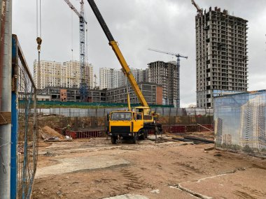 Bir kamyona monte edilmiş büyük sarı hareketlilik modern inşaat vinci büyük bir şehirde yeni evler, evler ve binalarda kullanılır..