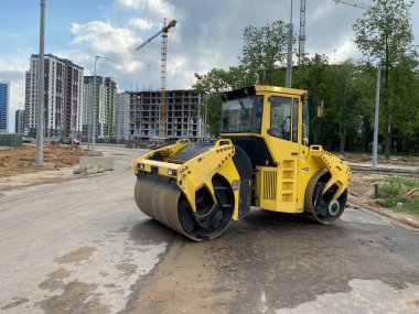 Asfalt asfalt asfalt döşeme ve inşaat alanında yol onarımı için sarı güçlü yeni modern yol silindiri. İnşaat makineleri.