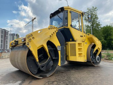 Asfalt asfalt asfalt döşeme ve inşaat alanında yol onarımı için sarı güçlü yeni modern yol silindiri. İnşaat makineleri.