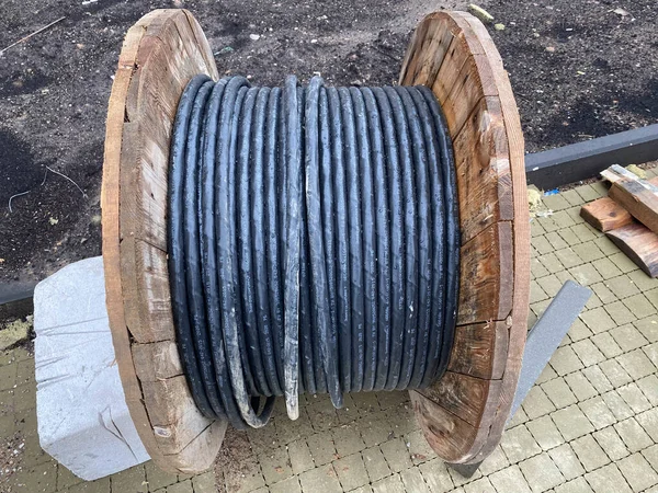 Een Dikke Elektrische Zwarte Kabel Opgerold Een Grote Houten Rol — Stockfoto