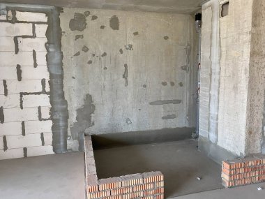 Yeni bir daire, onarımı ve tamiri olmayan yeni bir bina, betondan, tuğlalardan ve gaz silikat bloklarından yapılmış duvarları ve büyük panoramik pencereleri olan..