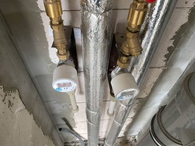 Yeni plastik ve polipropilen plastik ve polipropilen su ve kanalizasyon boruları termal yalıtım ile su sayaçları ile tamir edilmeyen yeni bir evde.