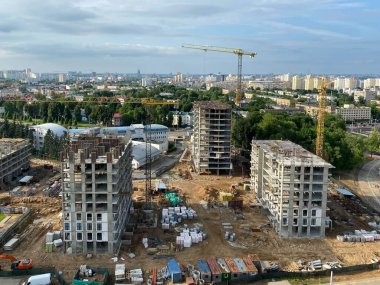Yüksek büyük evler ve çok katlı binalardan oluşan büyük ve modern bir inşaat alanının manzarası. Büyük bir şehirde yeni bir küçük bölgenin inşaatı için bir şantiye..