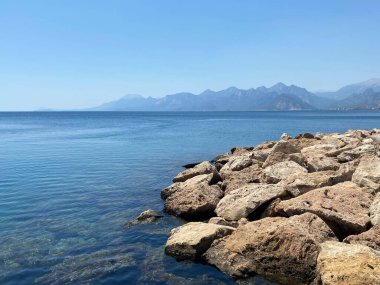 Tekneli Türkiye kıyıları, bir dağ manzarasının arka planına karşı.
