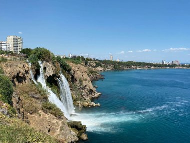 Türkiye 'nin Antalya kentindeki Lower Duden şelalesinin hava panoramik görüntüsü. Güneşli yaz gününde su kayalık kayalıklardan Akdeniz 'e düşüyor..