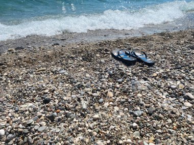 Sahildeki parmak arası terliklerin görüntüsü..