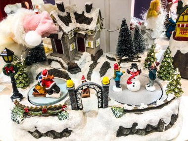 Yolu ve ışıkları olan küçük minyatür bir şehir. Kışın geceleri kar içinde dekoratif şirin evler. Yaratıcı tatil konsepti. Noel ve Yeni Yıl özellikleri dekore edilmiş kompozisyon.