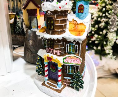 Noel ve yeni yıl tatili konsepti. Kışın kar altında küçük dekoratif şirin evler, güzel bir tatil arka planıyla karda duran firavun ağacı..