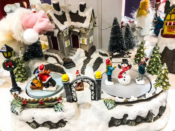 Yolu ve ışıkları olan küçük minyatür bir şehir. Kışın geceleri kar içinde dekoratif şirin evler. Yaratıcı tatil konsepti. Noel ve Yeni Yıl özellikleri dekore edilmiş kompozisyon.