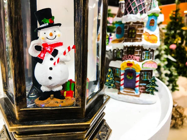 Minyatür kardan adam tahta oyuncağı, çam kozalağı, balo süsü ve Noel Baba şenlikleri için şapkası olan beyaz Noel arkaplanı..