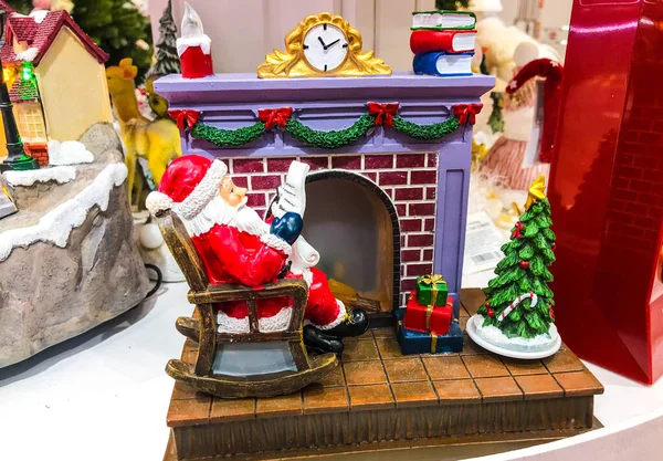 Siyah üzerine izole edilmiş kırmızı ve beyaz mini figür koleksiyonu. Noel süsü, kozalaklar, siyah arka planda şömine. Yakın çekim..