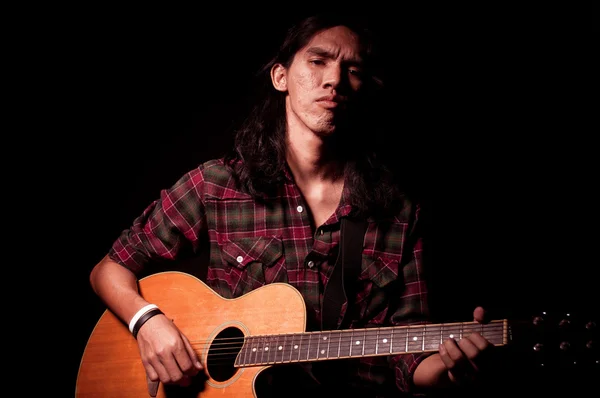 Tipo de pelo largo tocando la guitarra acústica —  Fotos de Stock