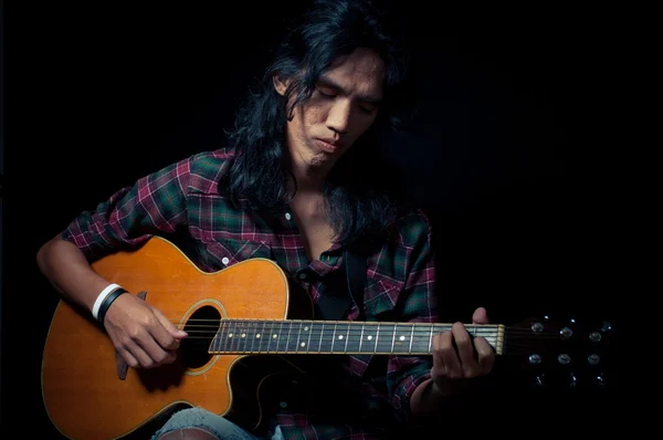 Długie włosy facet gra na gitarze akustycznej — Zdjęcie stockowe