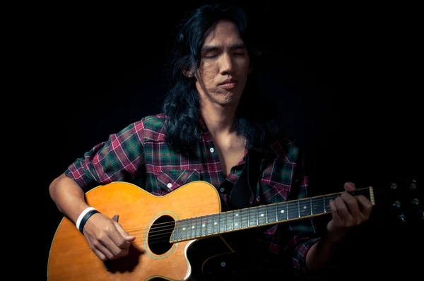 Tipo de pelo largo tocando la guitarra acústica —  Fotos de Stock