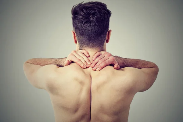 Back view of a young man with neck pain