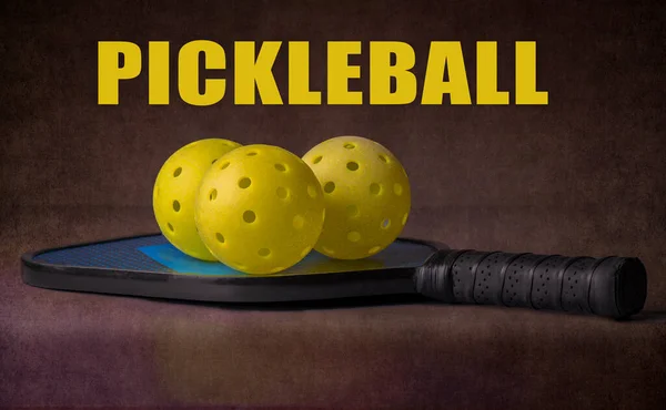 ピックルボールのパドルには3つのワッフルボールがあります Pickleball センタートップという言葉で暗い背景 — ストック写真