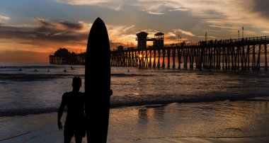 Silhouette of surfer near the ocean clipart