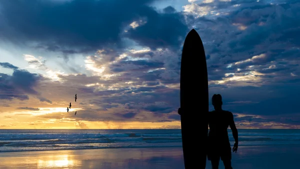 Silhouet van surfer in de buurt van de Oceaan — Stockfoto
